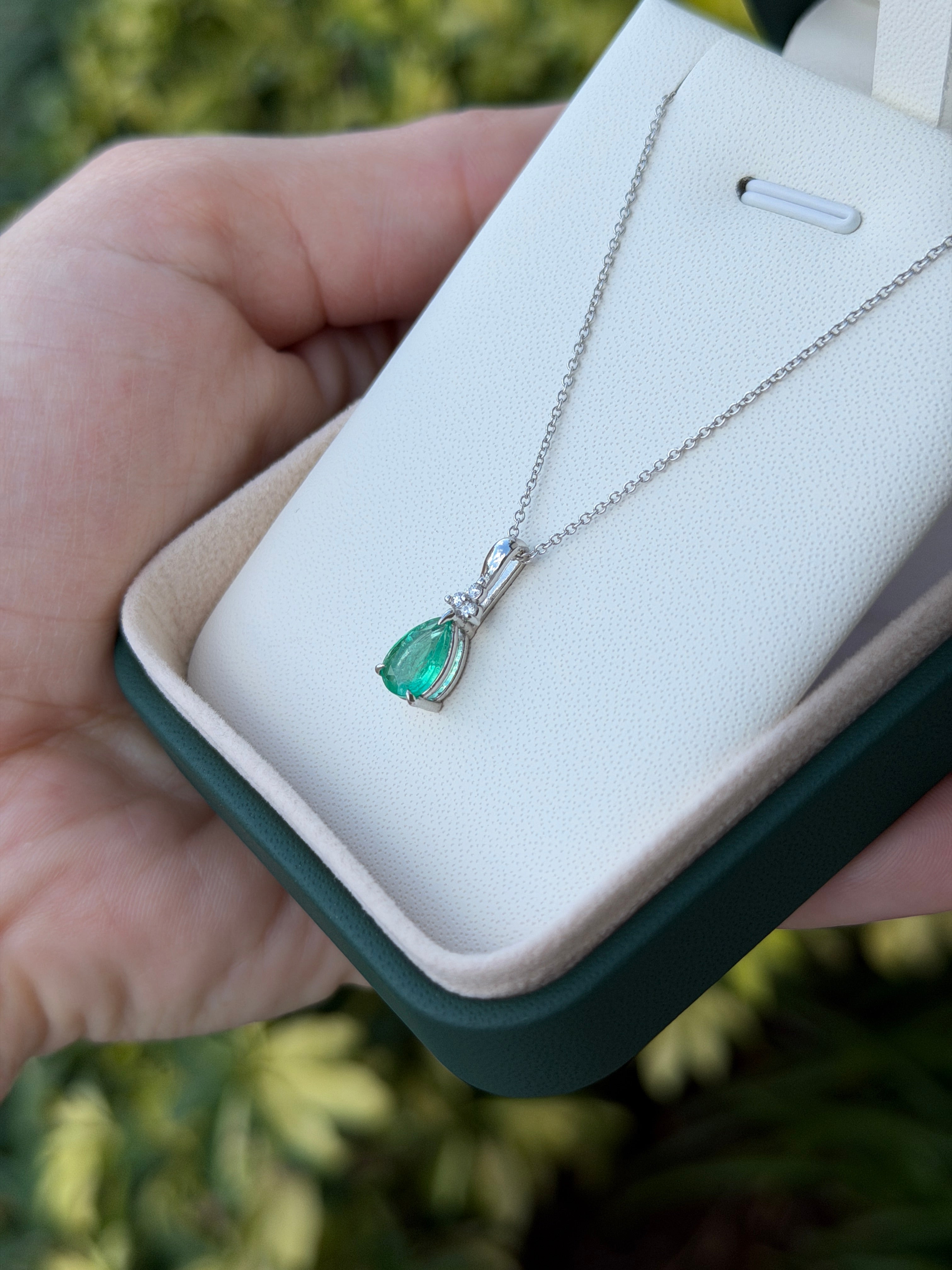 Pear-shaped emerald drop pendant with trefoil diamond cluster in 14K white gold, featuring 1.04tcw of gemstones.