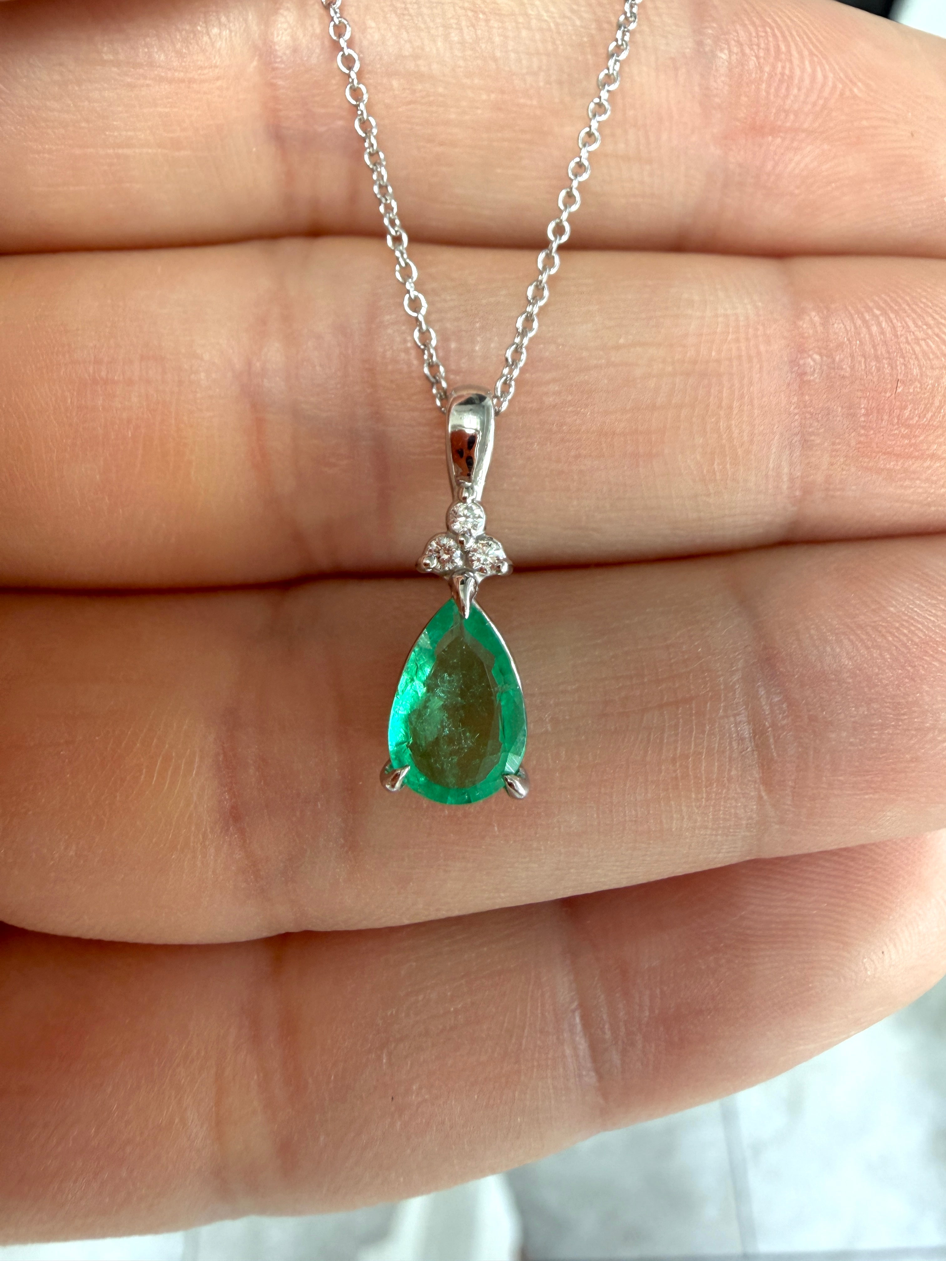 Pear-shaped emerald drop pendant with trefoil diamond cluster on 14K white gold, featuring 1.04 carats total weight.