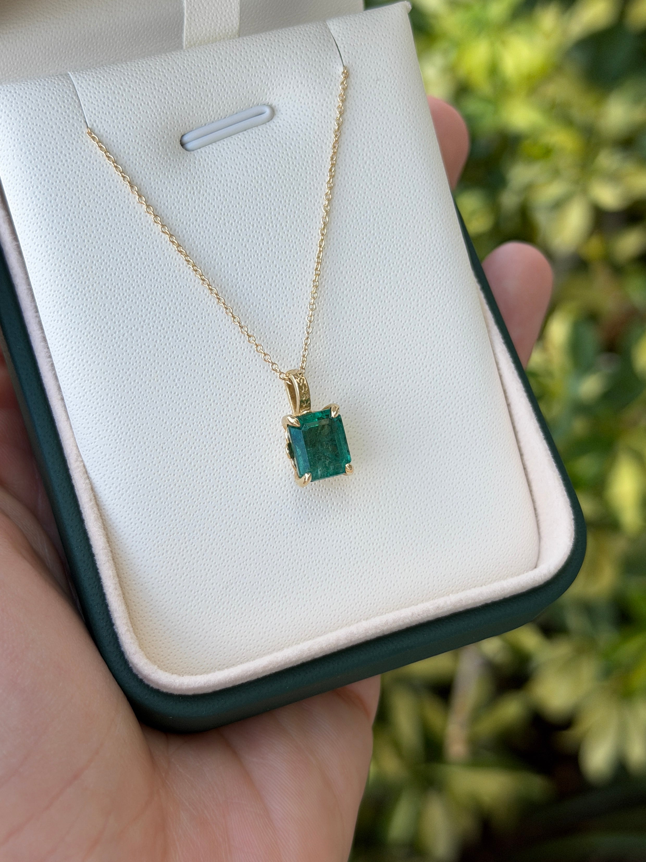 14K gold solitaire emerald necklace with 3.50 carat fleur de lis design by JR Colombian Emeralds, featuring a central emerald gemstone.