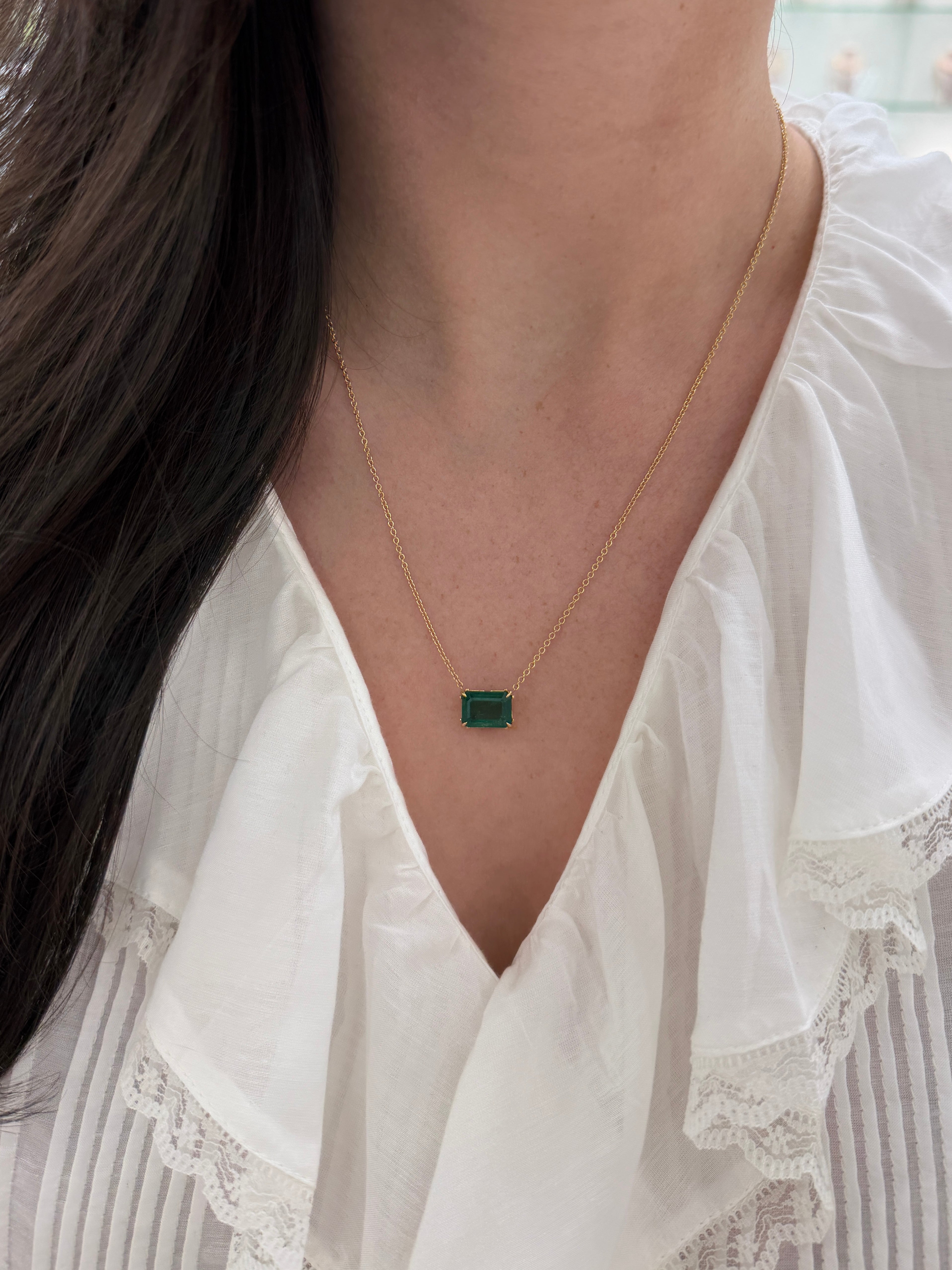 East to west emerald solitaire necklace with floral-inspired fleur de lis design, featuring a 5.70ct 18K gold setting by JR Colombian Emeralds