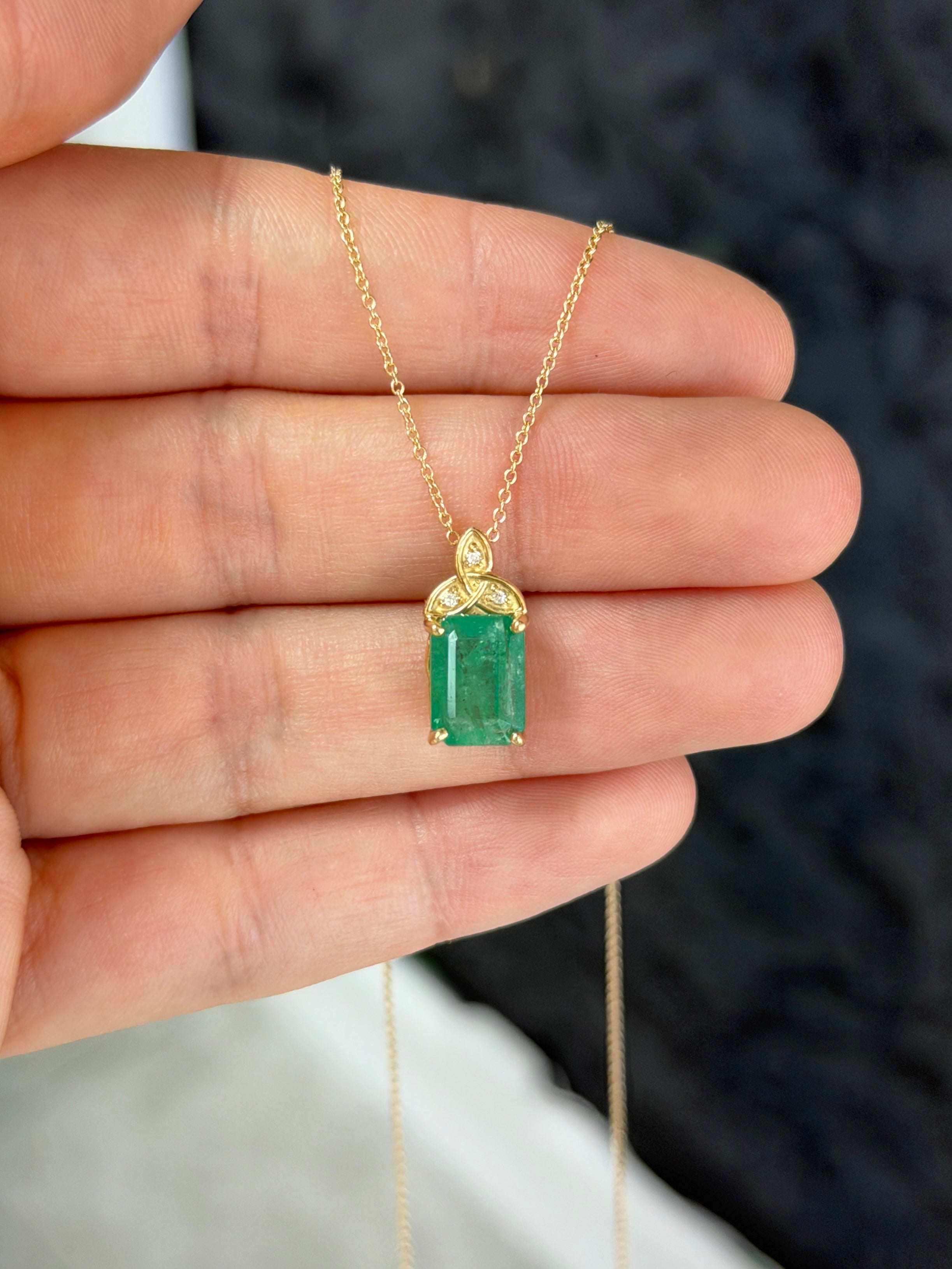 14K yellow gold Trinity Knot emerald solitaire necklace with 2.12 carats from JR Colombian Emeralds, featuring a central emerald gemstone.