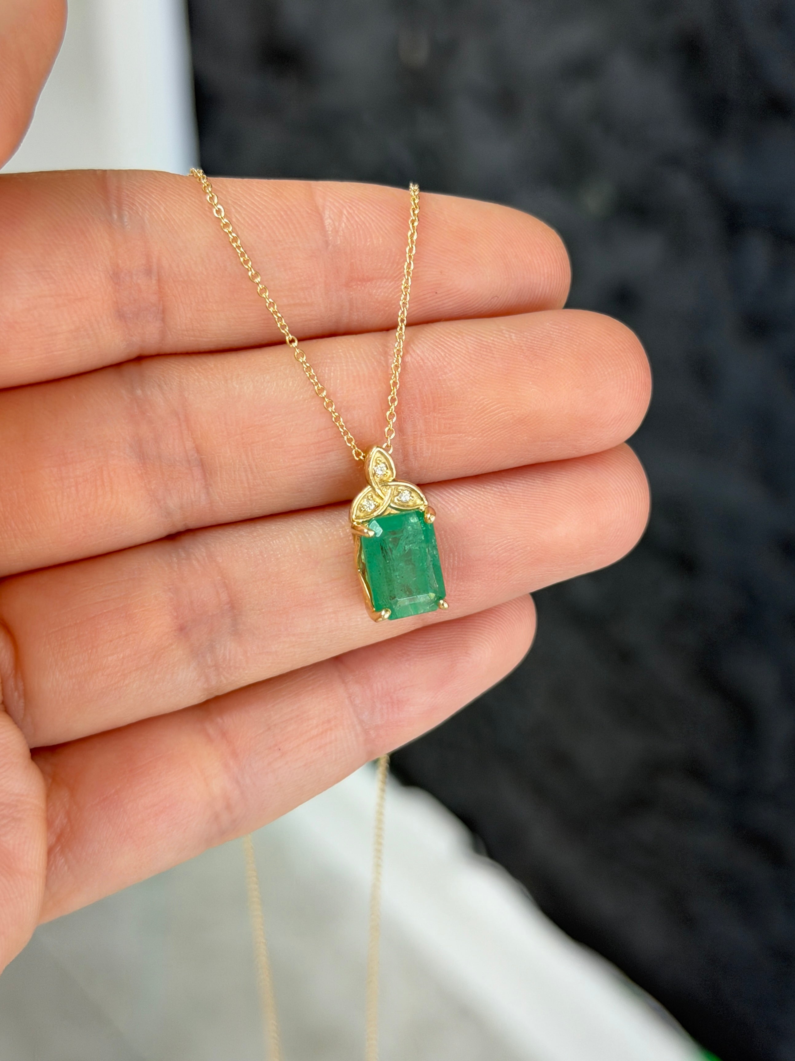 14K yellow gold Trinity Knot emerald solitaire necklace with 2.12 carats from JR Colombian Emeralds, close-up view of the pendant.