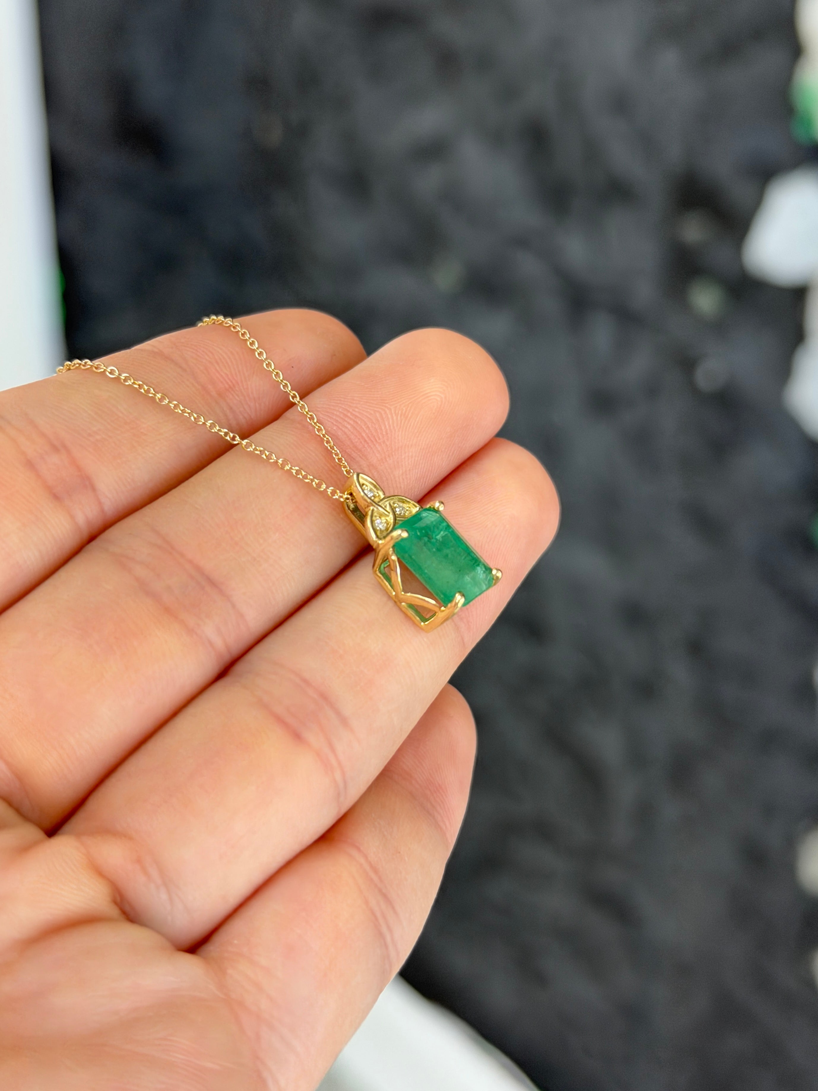 14K yellow gold Trinity Knot emerald solitaire necklace with 2.12tcw gemstone, featuring a delicate chain and elegant design.