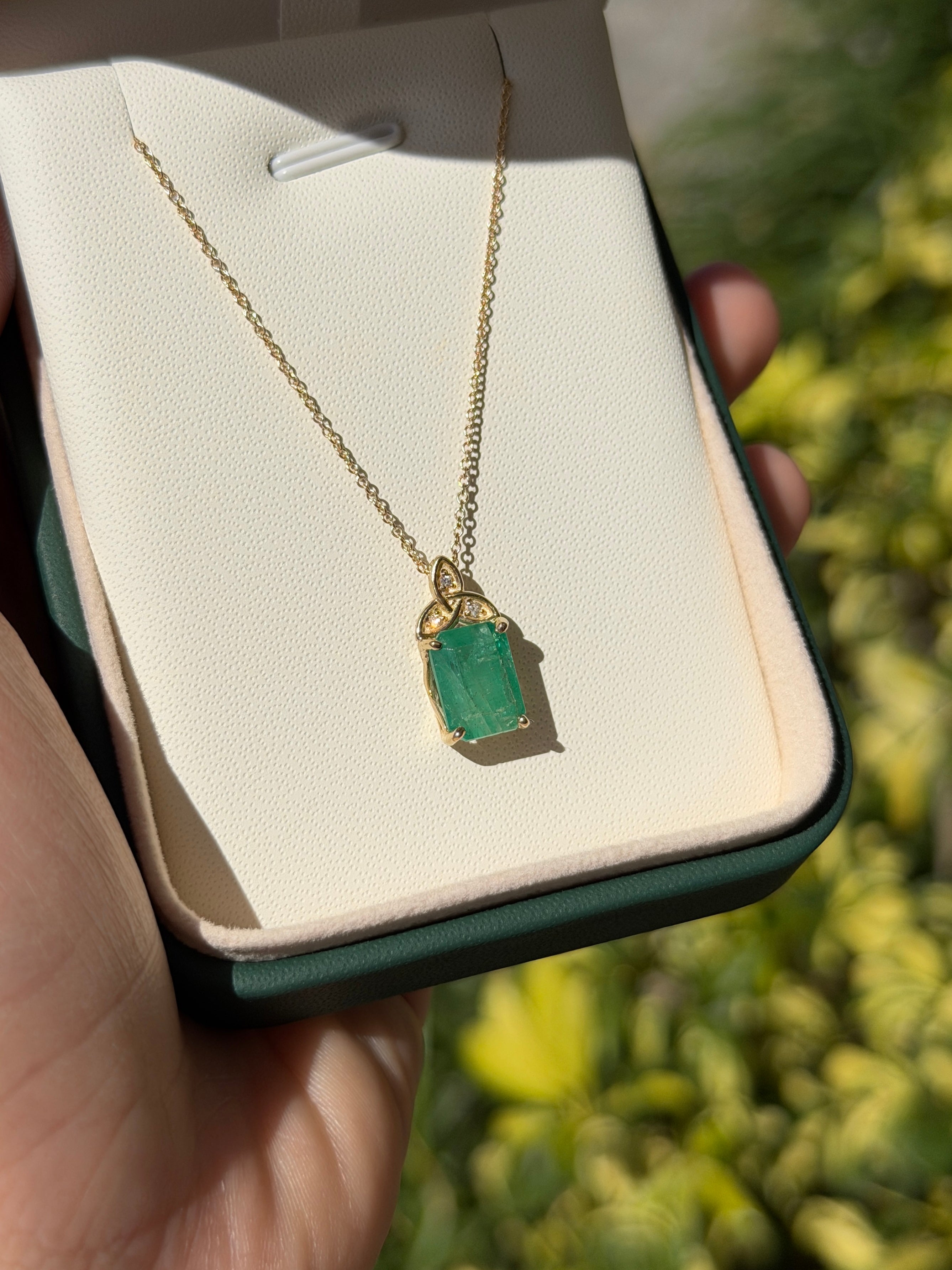 14K yellow gold Trinity Knot emerald solitaire necklace with 2.12tcw from JR Colombian Emeralds, showcasing a detailed pendant.