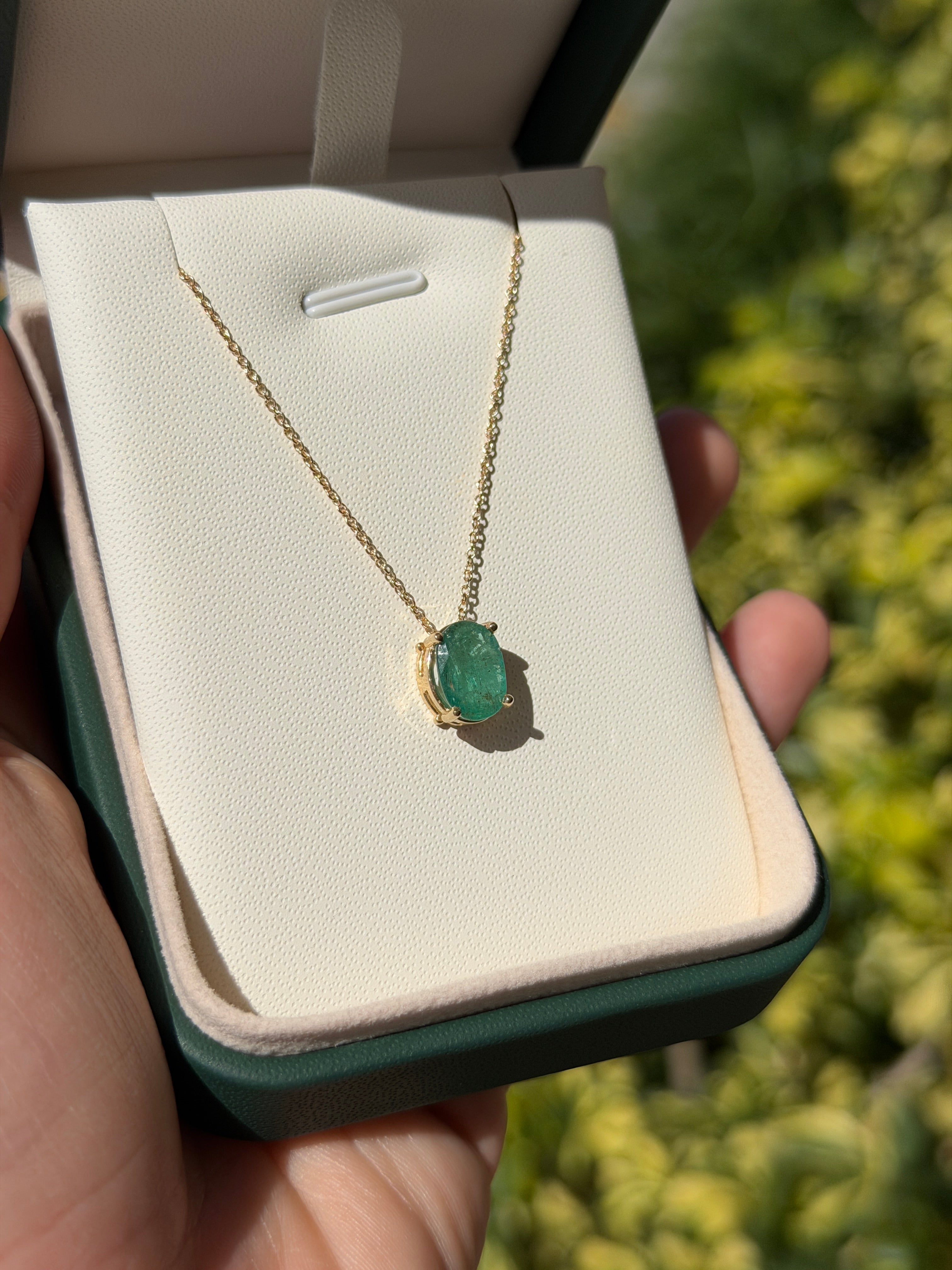 14K gold solitaire emerald oval slider necklace with 2.15 carat emerald by JR Colombian Emeralds, shown with the necklace laid flat.