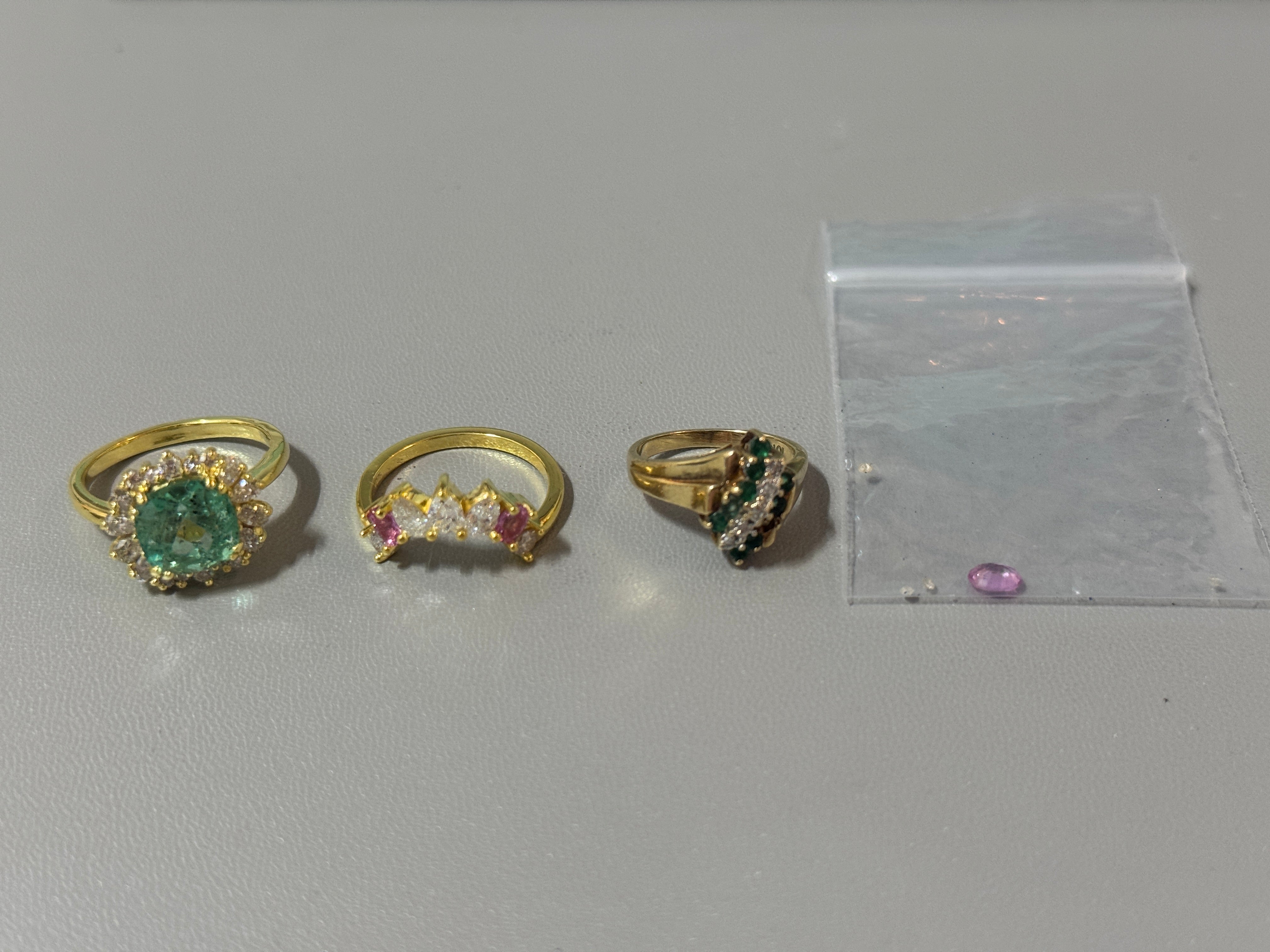 Jewelry parcel with ring repair tools and emerald jewelry from JR Colombian Emeralds, displayed on a neutral background.