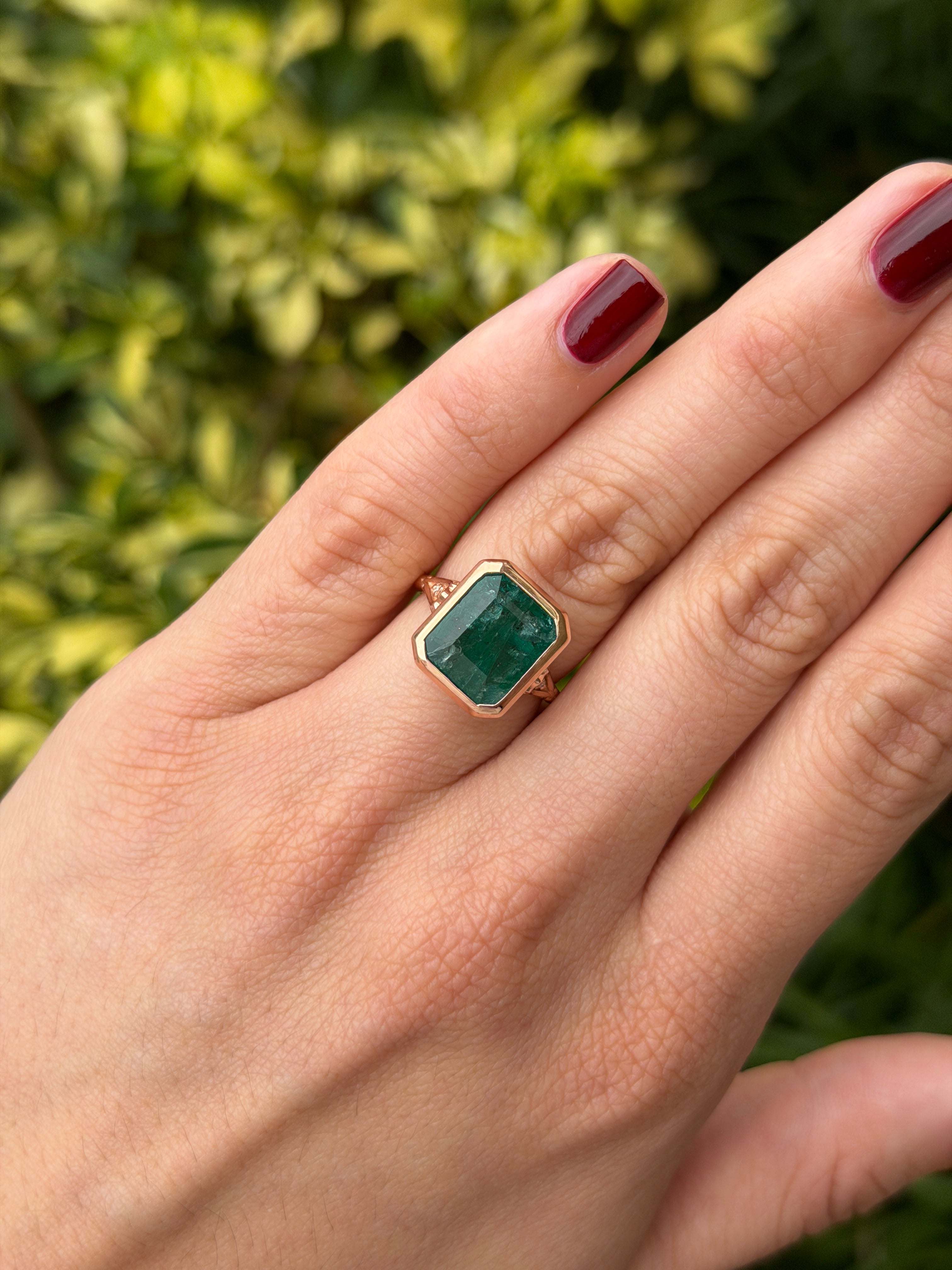 Vintage-inspired 14K rose gold emerald bezel ring with diamond shank and scroll basket detail, featuring 6.20 tcw emeralds from JR Colombian Emeralds.