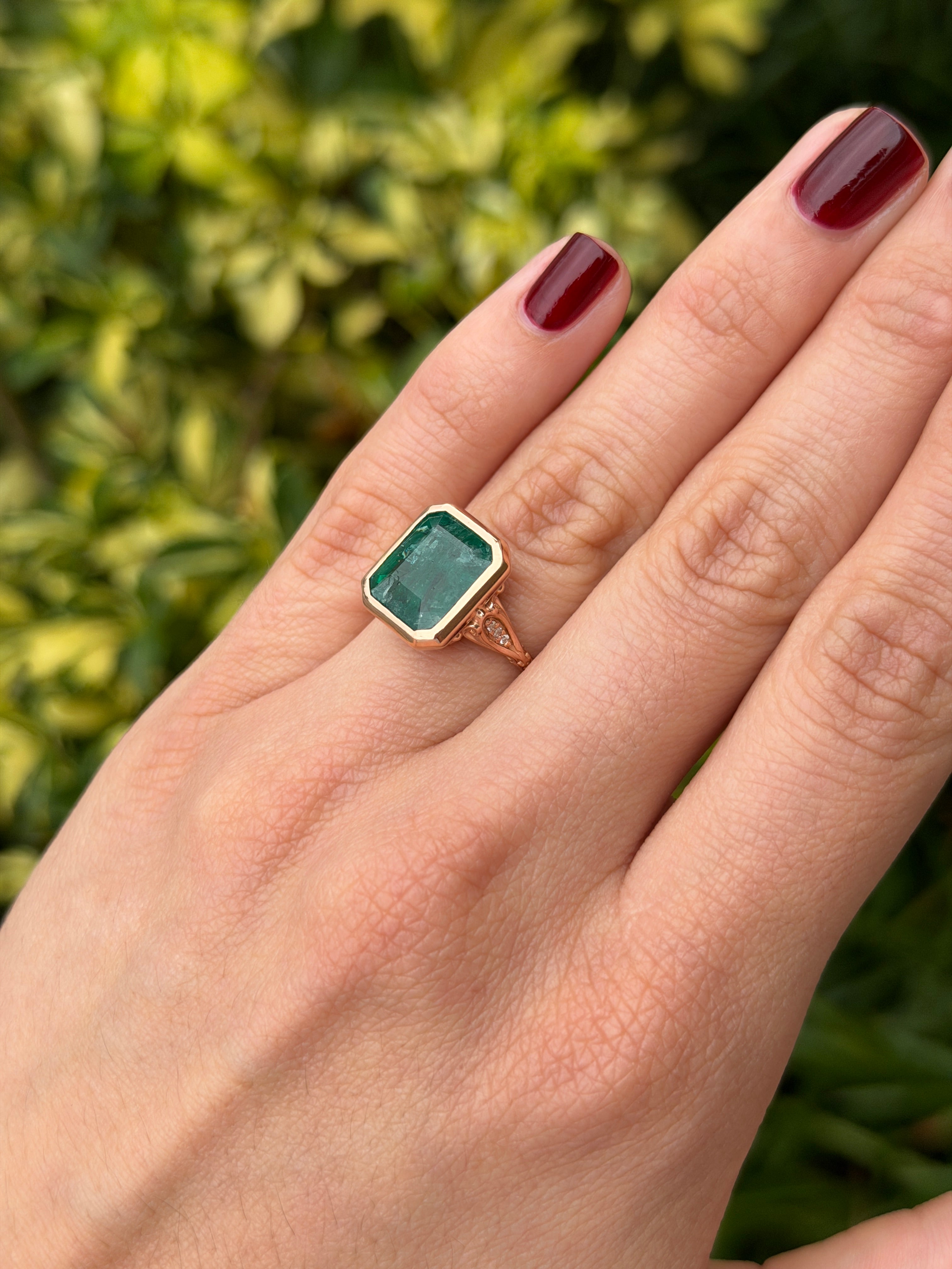 Vintage-inspired emerald bezel ring with diamond shank and scroll basket detail in 14K rose gold by JR Colombian Emeralds.