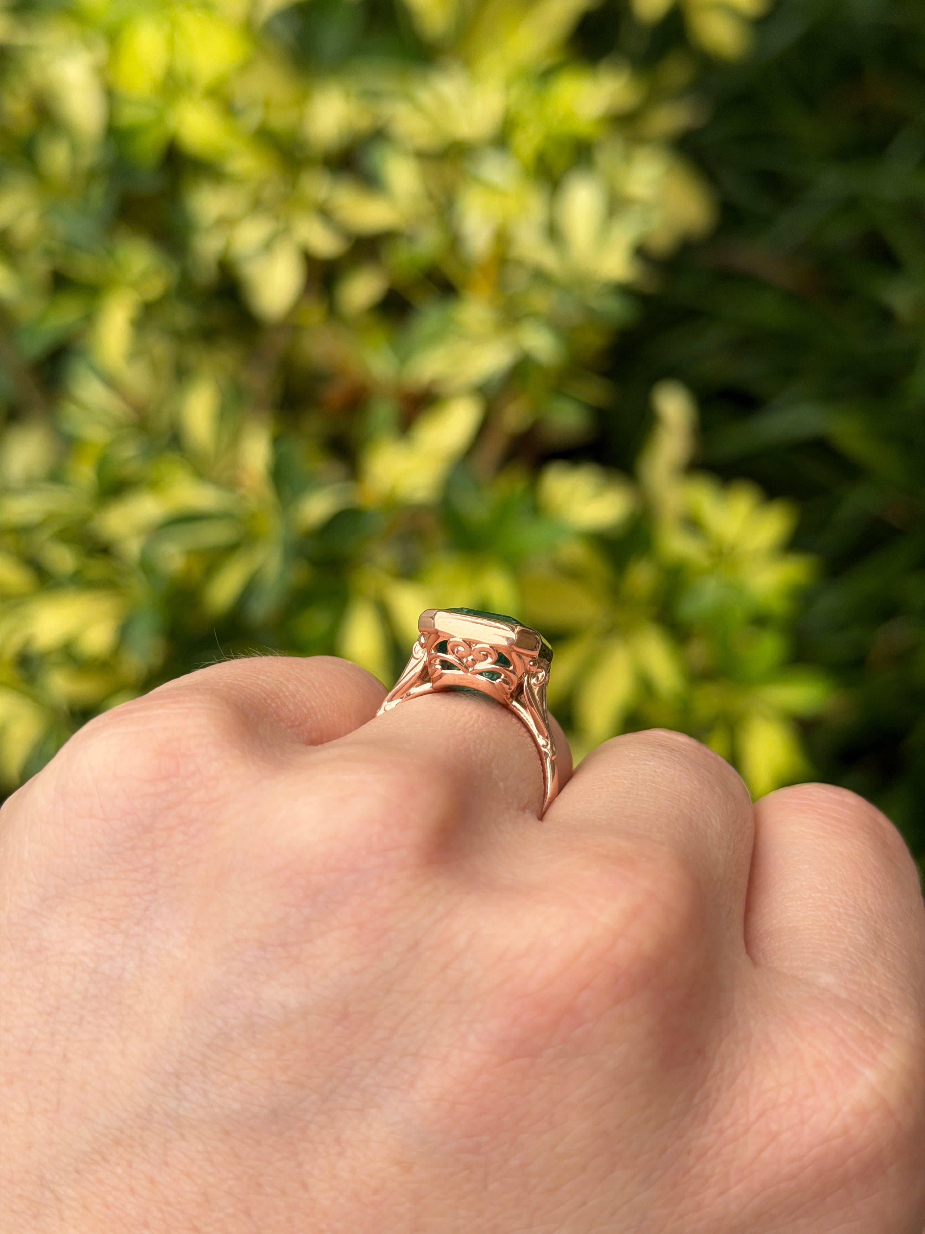 Vintage-inspired emerald bezel ring with diamond shank and scroll basket detail in 14K rose gold by JR Colombian Emeralds.