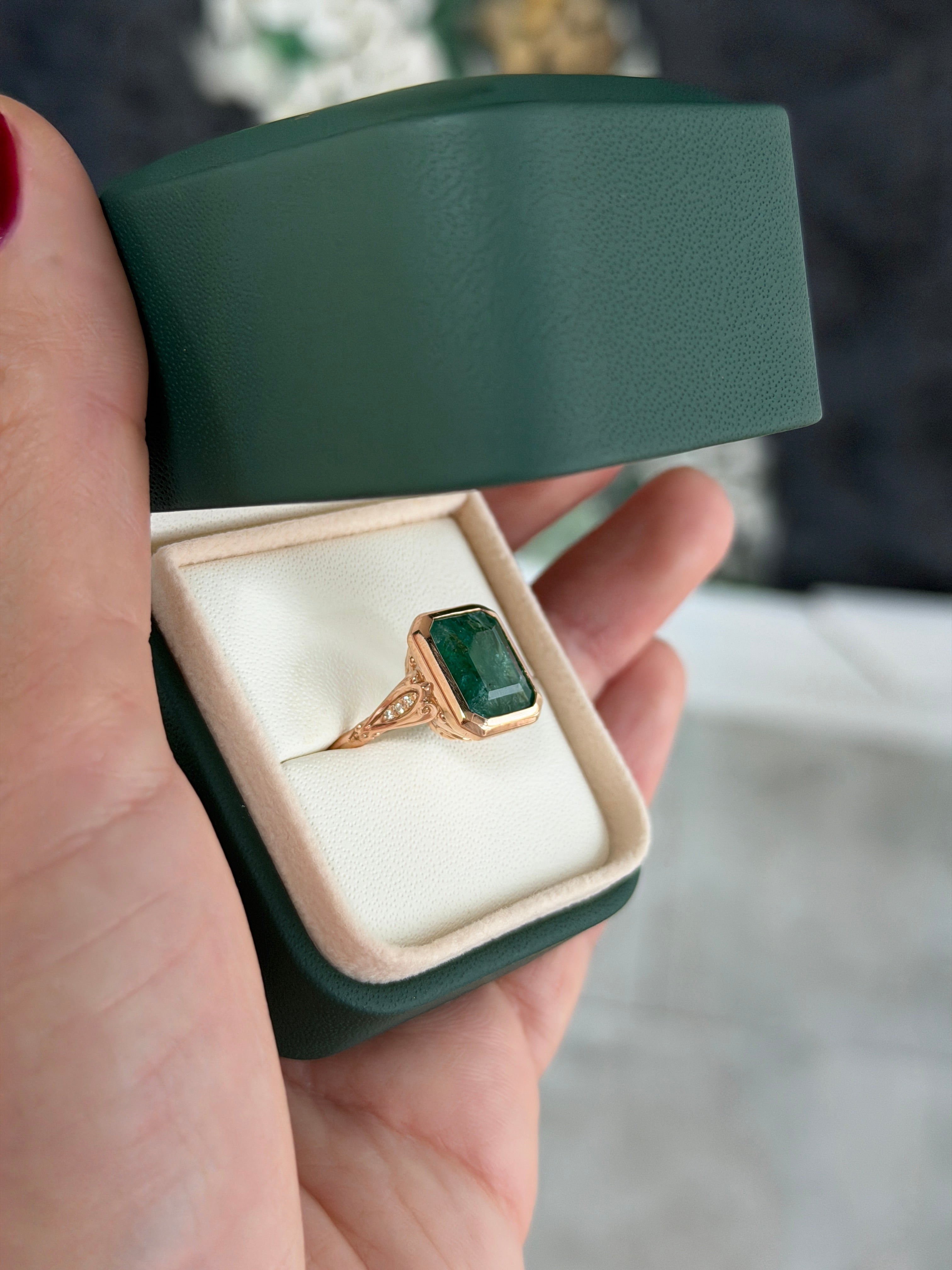 Vintage-inspired 14K rose gold emerald bezel ring with diamond shank and scroll basket detail by JR Colombian Emeralds.