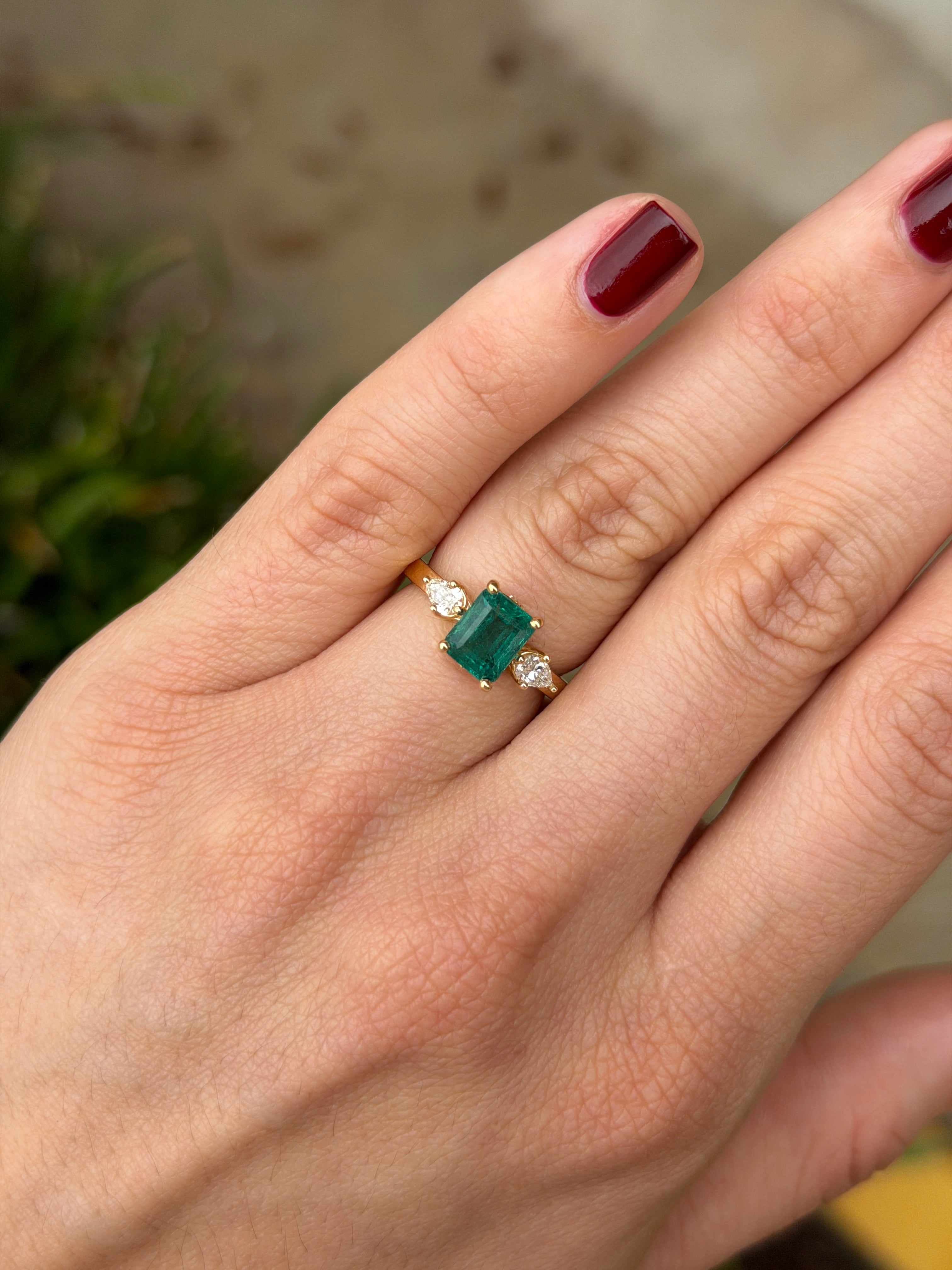 Anello a tre pietre con smeraldo taglio smeraldo e a forma di pera e diamanti, con dettagli nascosti in diamanti, in oro 18 carati, firmato JR Colombian Emeralds.