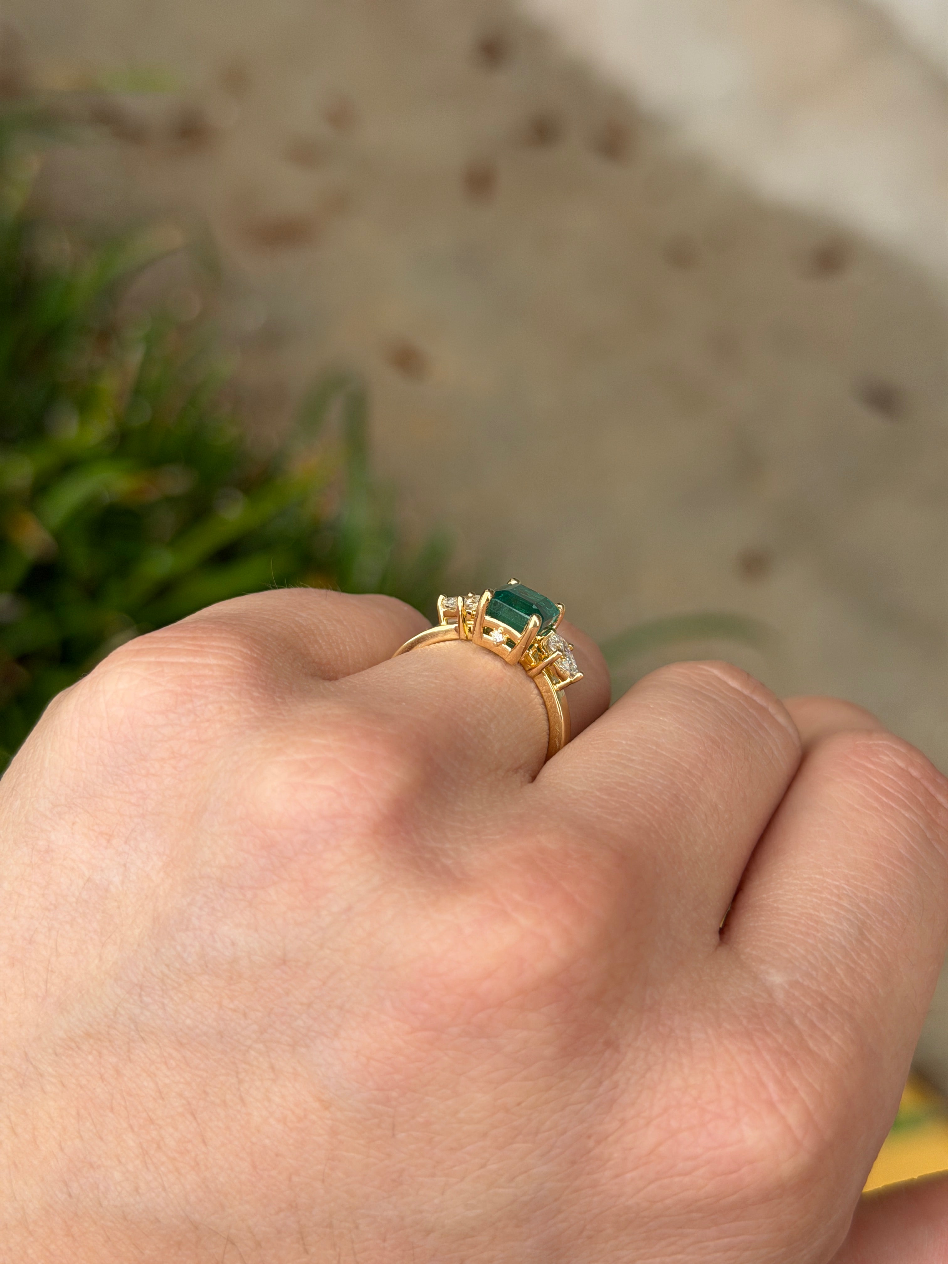 Emerald cut and pear-shaped emerald and diamond three-stone ring with hidden diamond accents in 18K gold by JR Colombian Emeralds.