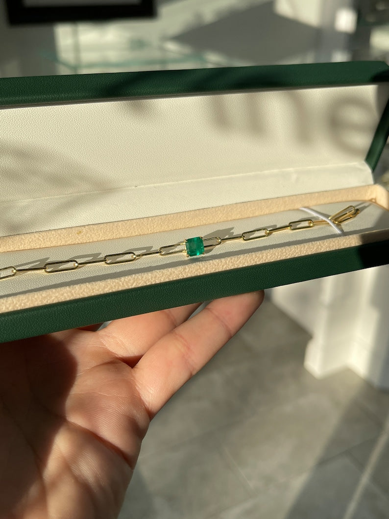 Colombian Emerald dark green 1.80ct Asscher cut emerald bracelet with 14K gold paperclip design and 4-claw prong setting.