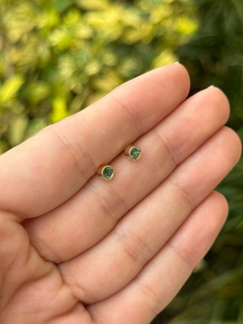 Colombian Emerald 14K yellow gold earrings with 0.50tcw natural lush medium green round-cut bezel-set gemstones.