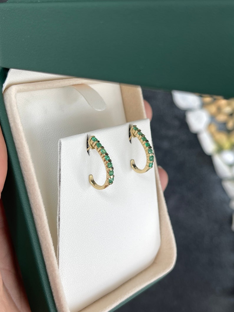 Natural round emerald half J-hoop earrings in 14K gold with 0.75 carats from Colombian Emerald brand.