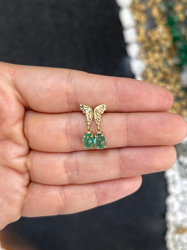 Colombian Emerald 14K gold dangle earrings with oval cut green cabochon emeralds and half butterfly design, elegant jewelry.