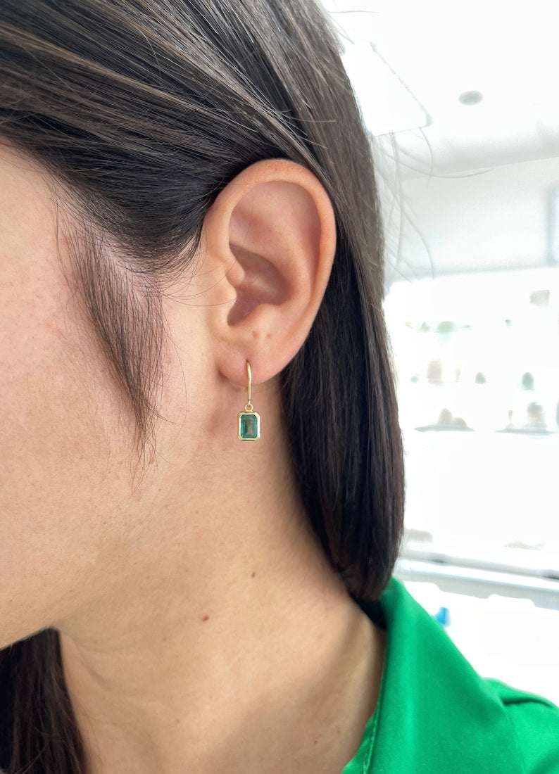 Pair of Colombian Emerald 14K gold dangle earrings with classic emerald cut ear wire backs, showcasing elegant jewelry design.