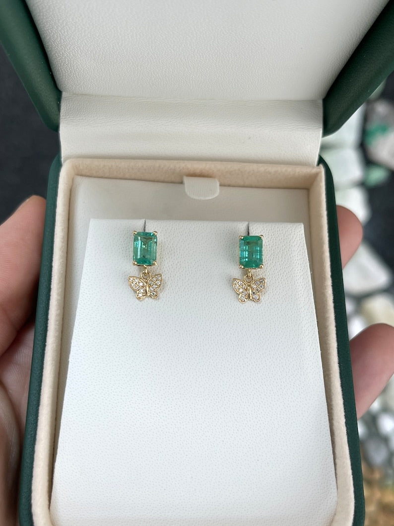 14K gold butterfly dangle earrings with natural emeralds and diamonds, featuring 2.40tcw in a vibrant, elegant design.