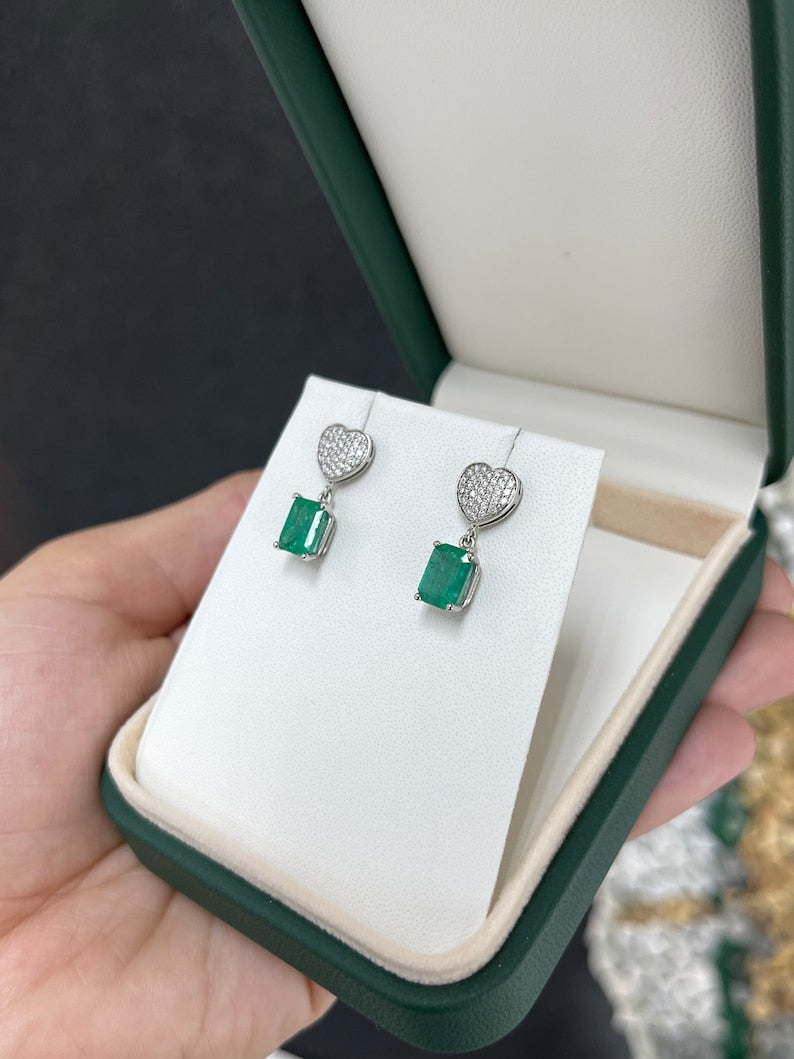Colombian Emerald and Diamond Heart Cluster Dangle Earrings in 14K yellow gold, featuring 3.20tcw natural rich medium green emeralds.