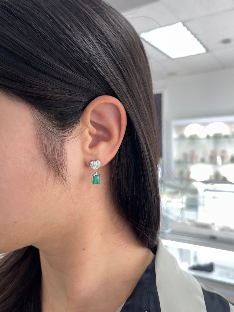 Natural green emerald and diamond heart cluster dangle earrings in 14K gold by Colombian Emerald, featuring rich green gemstones.