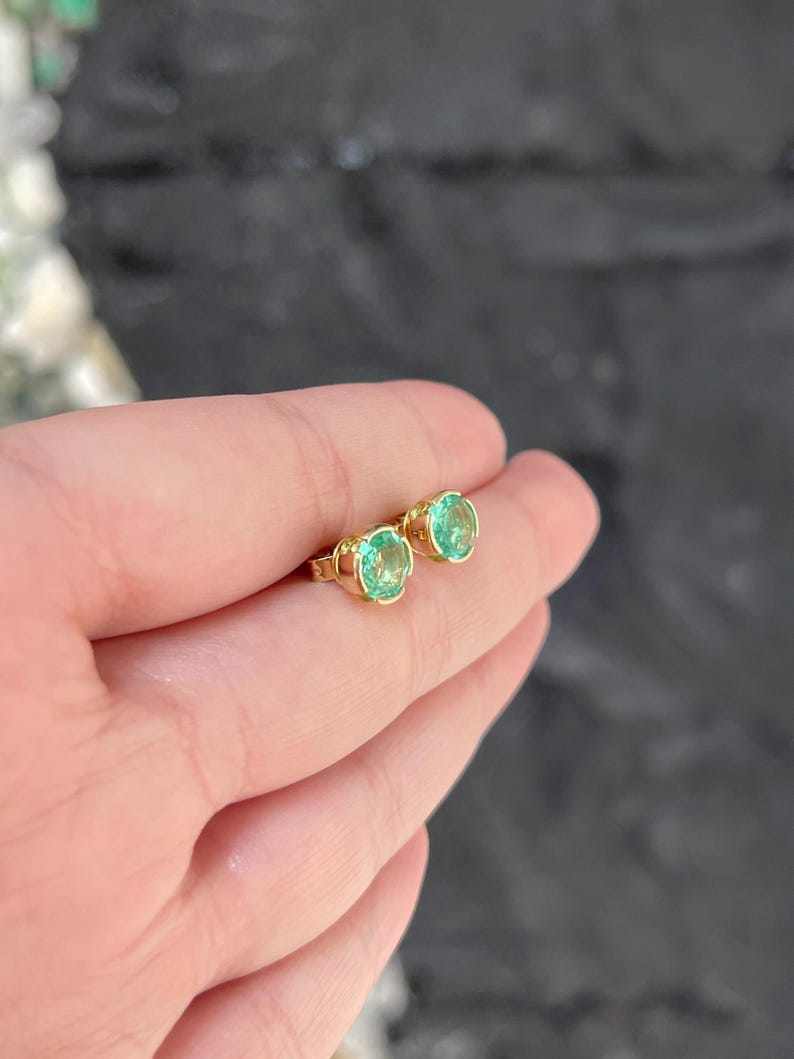 14K Colombian Emerald stud earrings with round, semi-bezel set emeralds totaling 2.0 carats, featuring a classic earring design.