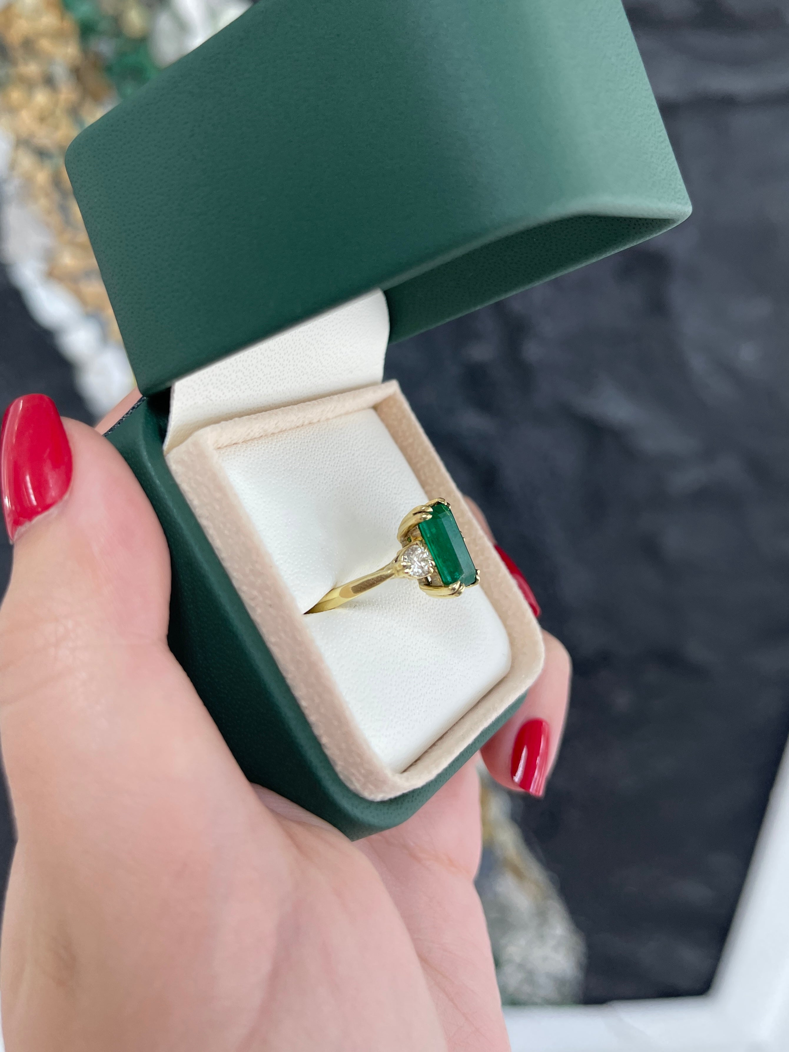 Colombian Emerald natural three-stone engagement ring with 2.78 carats of emerald cut and round diamonds in 18K gold setting.
