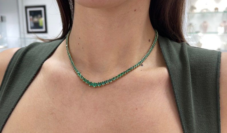 Colombian Emerald 22.0tcw 14K yellow gold graduating round tennis necklace with vivid medium dark green emeralds.