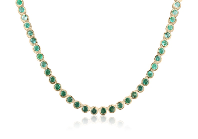 14K green emerald tennis necklace with round medium-cut Colombian emeralds totaling 25.50 carats, bezel-set in elegant jewelry.