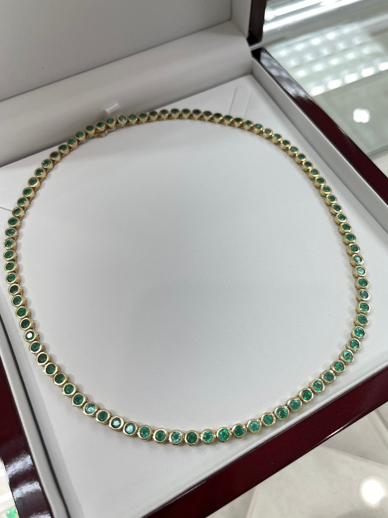 Colombian Emerald tennis necklace with 25.50tcw 14K gold bezel-set round medium green emeralds, elegant jewelry piece.