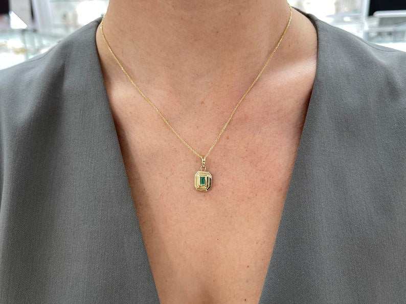 14K gold unisex pendant necklace featuring a 0.40ct lush green natural North-South emerald cut bezel set from Colombian Emerald.