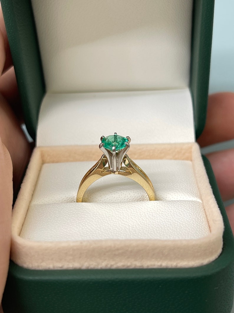 Two-toned 14K emerald and diamond accent engagement ring with round cut center by Colombian Emerald, featuring a six-prong setting.