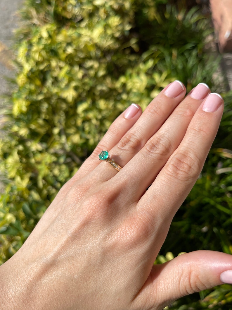 Two-toned 14K emerald and diamond accent engagement ring with round cut center stone and six-prong setting by Colombian Emerald