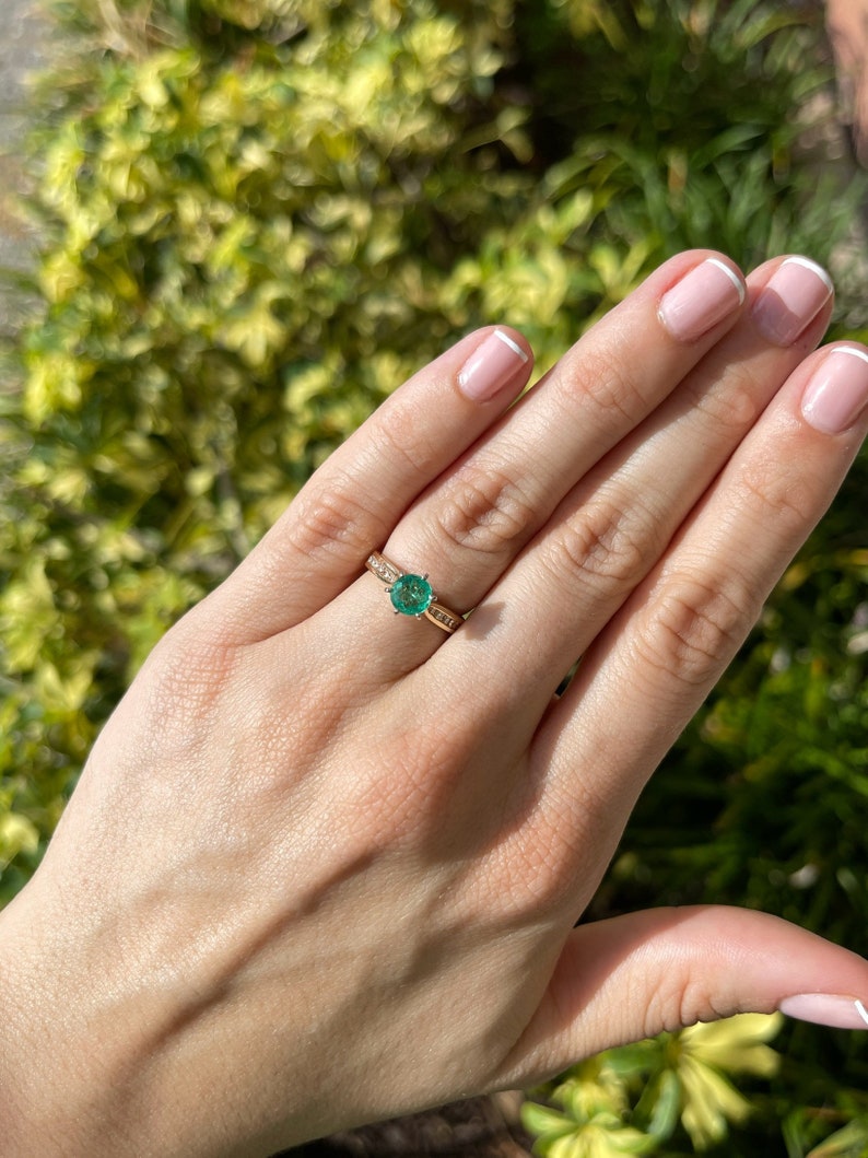 Two-toned 14K emerald and diamond accent engagement ring with round cut center stone, featuring a 6-prong setting, by Colombian Emerald.