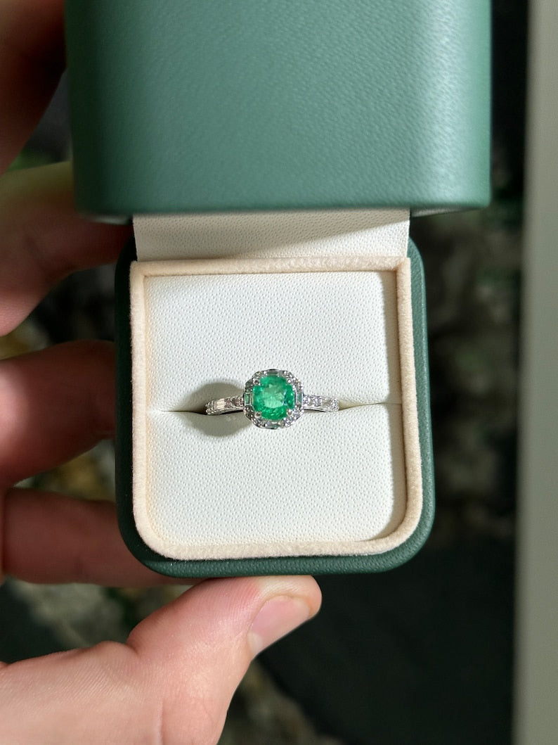 14K Colombian Emerald engagement ring with a vivid green cushion cut emerald, round diamonds, and baguette halo setting.
