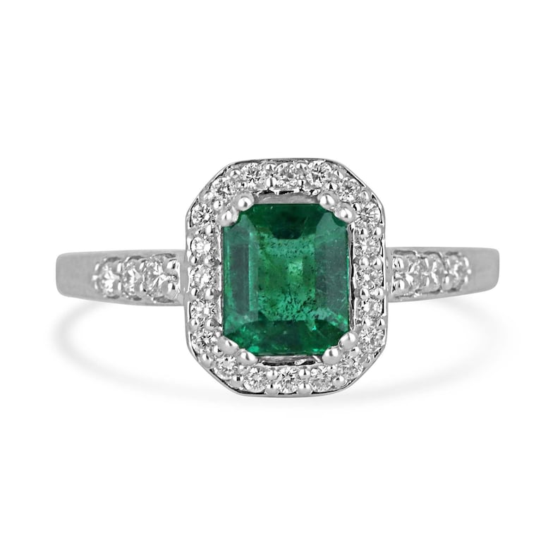 Zambian emerald cut emerald and diamond halo engagement ring in 14K gold, featuring a 1.60tcw high-quality center stone.