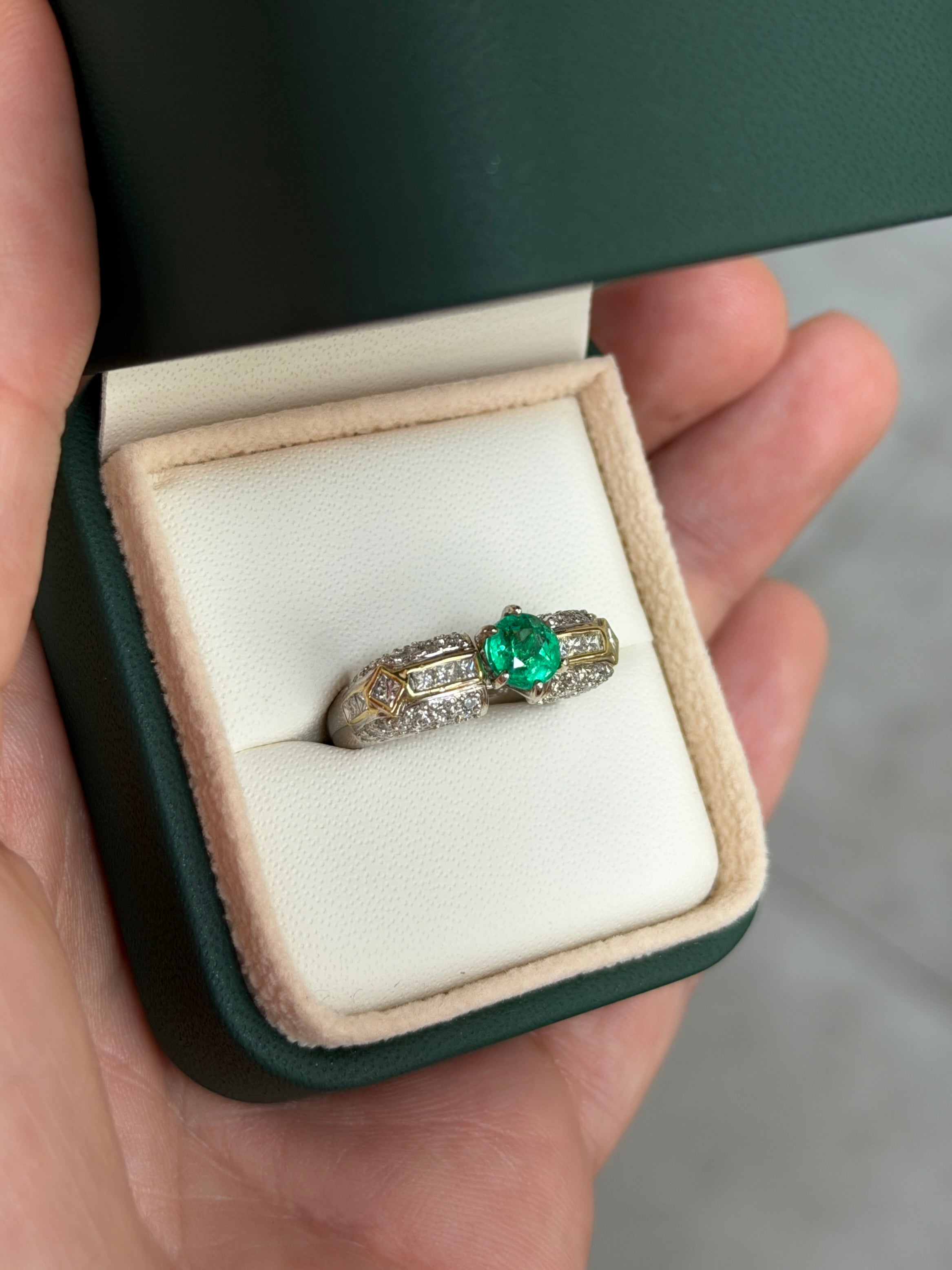 18K gold engagement ring with a 1.85 carat round cut Colombian emerald and diamond accents, showcasing elegant craftsmanship.