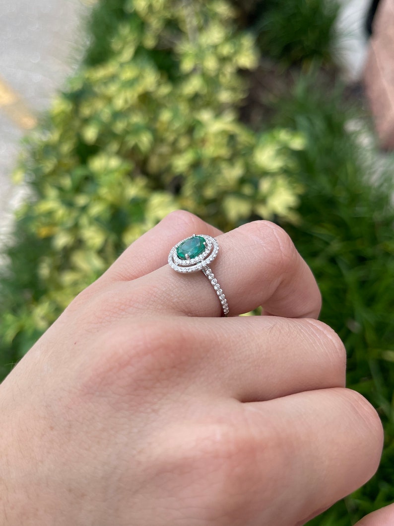 Colombian Emerald 1.90tcw rich green oval cut emerald engagement ring with double diamond halo in 14K gold.
