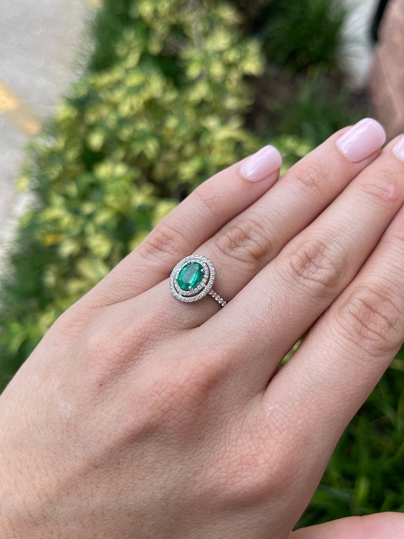 Colombian Emerald 1.90tcw lush green 8x6 oval cut emerald engagement ring with double diamond halo in 14K gold.