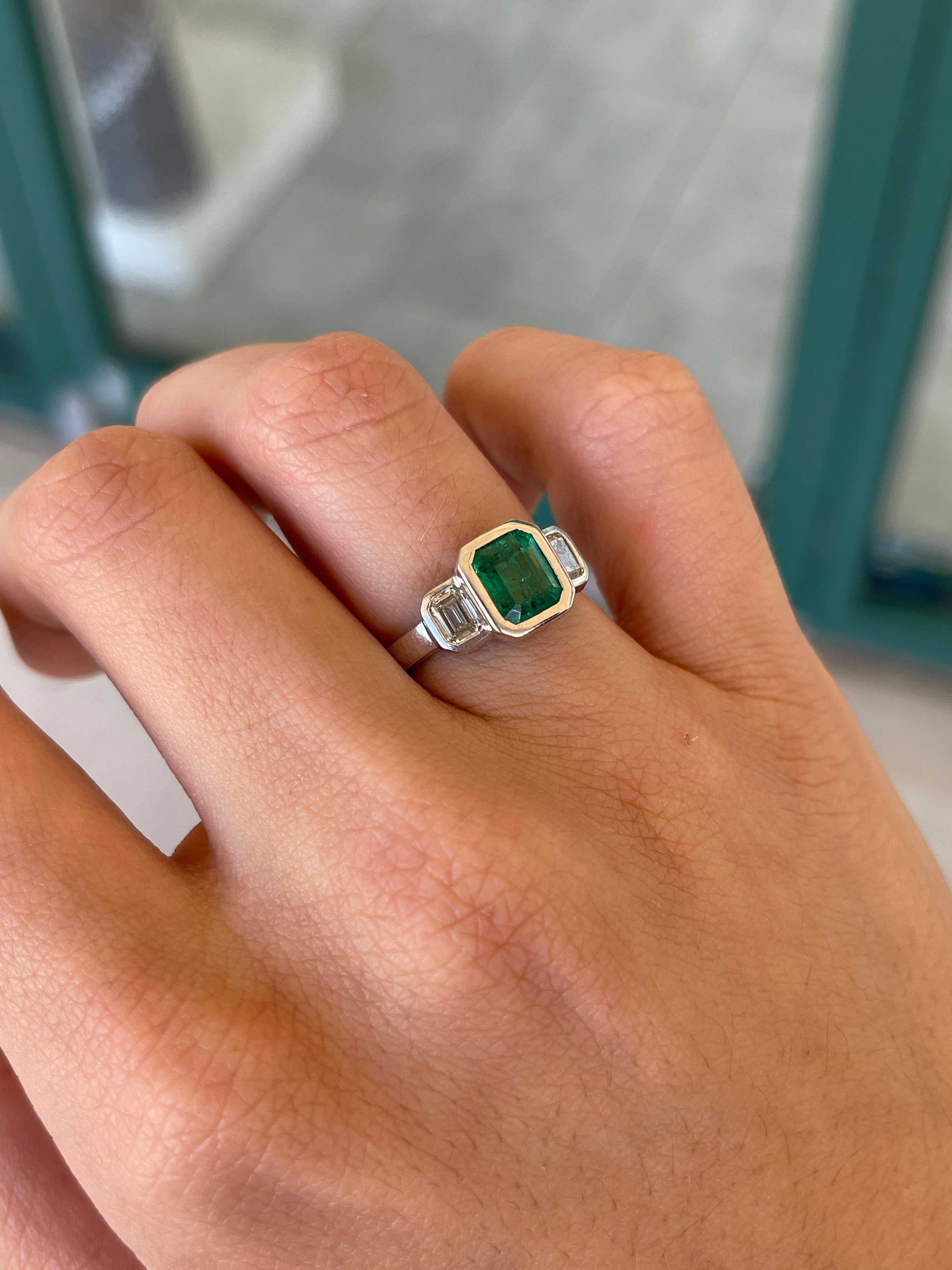 14K gold engagement ring with three emerald-cut diamonds totaling 2.25 carats, featuring natural GIA-certified Colombian emeralds.