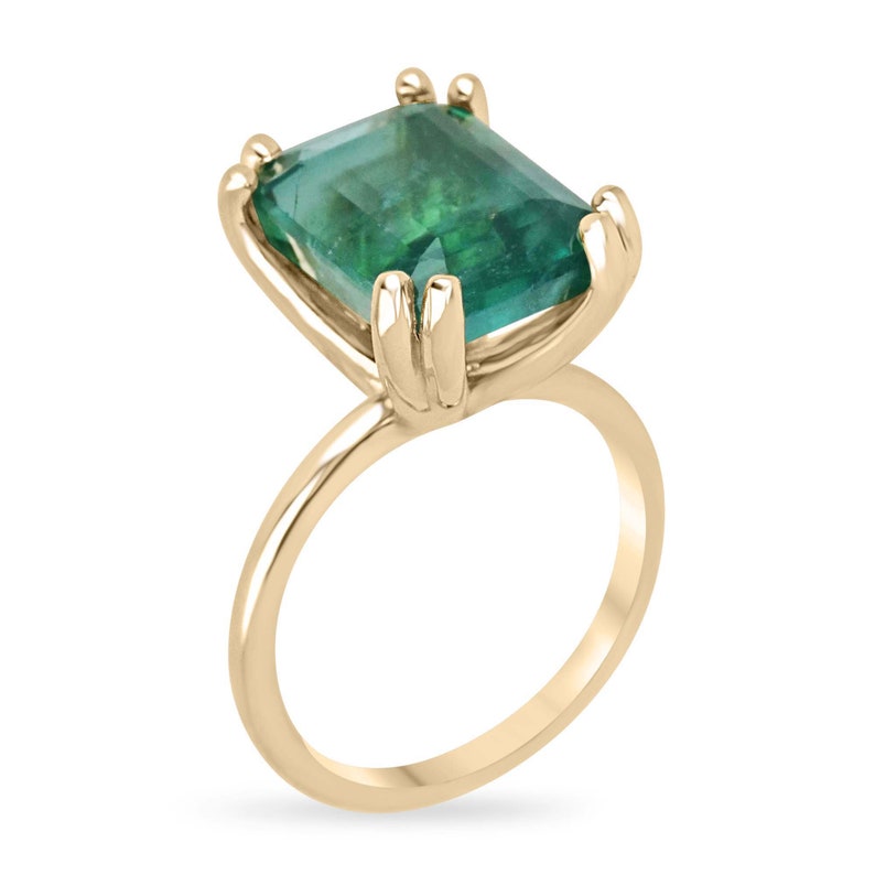 14K Colombian Emerald cut solitaire engagement ring with chunky claw prongs, featuring a 7.35 carat emerald gemstone.