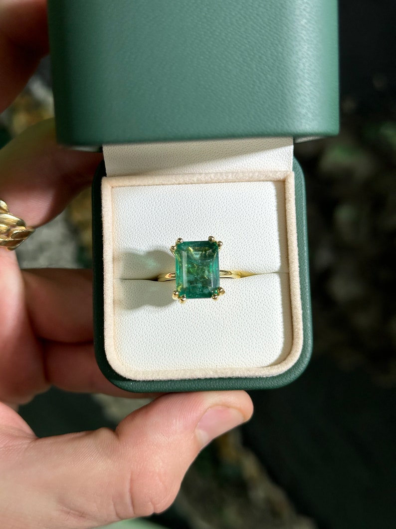 Colombian Emerald 14K engagement ring with a 7.35ct emerald cut solitaire gemstone and chunky claw prongs.