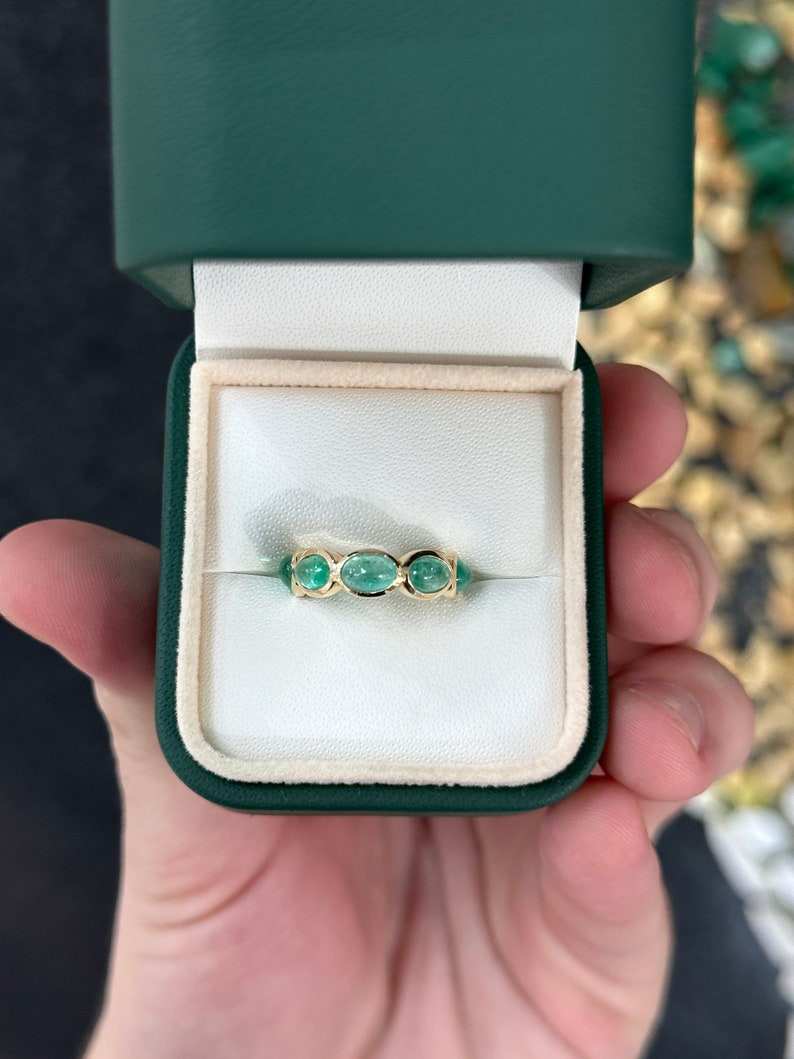 Ladies Colombian emerald eternity band ring in 14K yellow gold with a 3.60tcw east-to-west oval cabochon cut emerald, size 5.25.