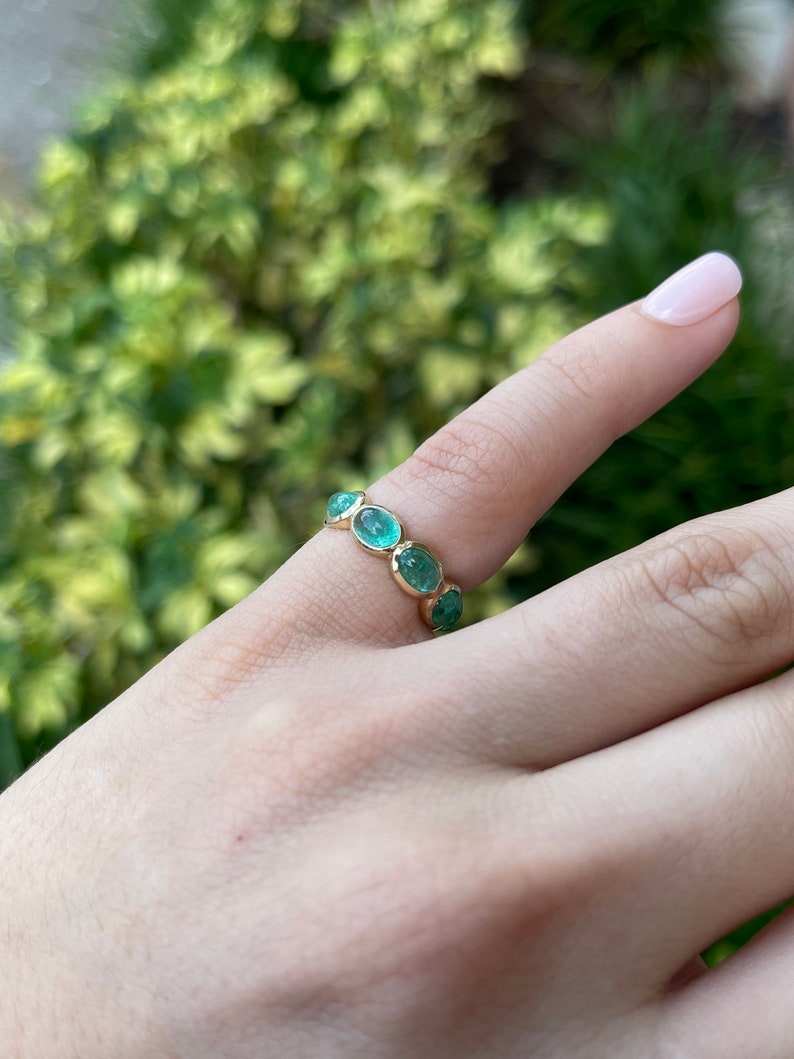 Ladies Colombian Emerald wedding band in 14K yellow gold featuring a 3.60tcw east-to-west oval cabochon cut emerald.