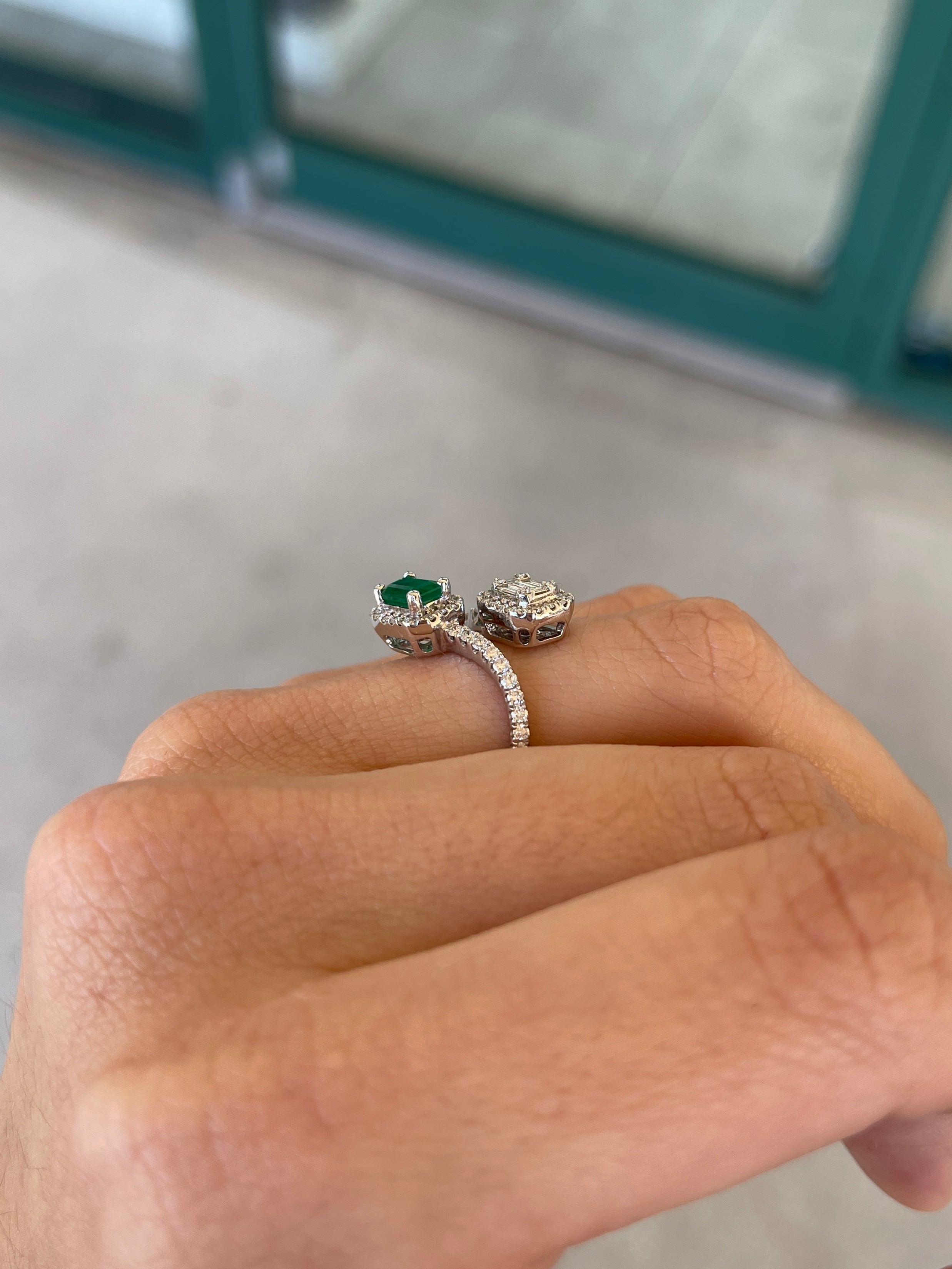 Ladies emerald ring featuring 1.51 tcw Colombian emeralds, baguette and round cut gemstones, 14K gold bypass shank design