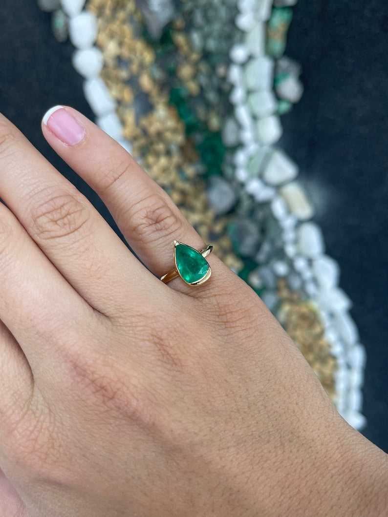 Ladies emerald ring featuring a 3.10ct dark green pear-shaped Colombian emerald set in 18K gold.