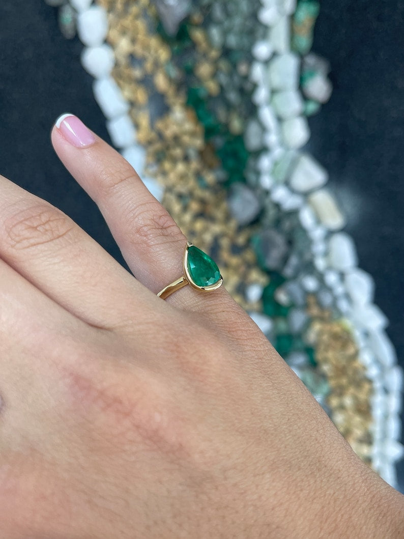 Ladies emerald ring featuring a 3.10ct lustrous dark green pear-shaped Colombian emerald in 18K gold solitaire setting