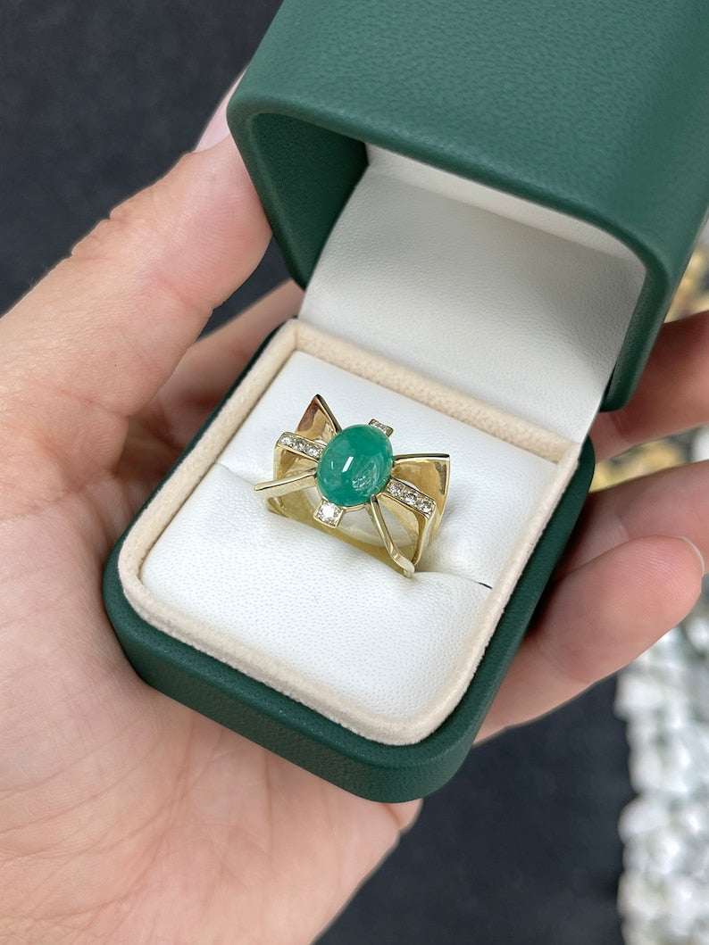 Lady's gold emerald statement ring with a 5.12tcw green cabochon emerald and diamond accents, styled in a star design.