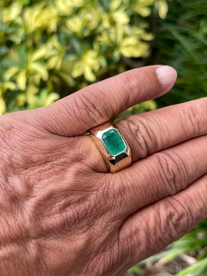 Men's 14K gold ring featuring a 4.40ct dark green emerald solitaire bezel setting, Colombian Emerald brand, heavy and elegant design.