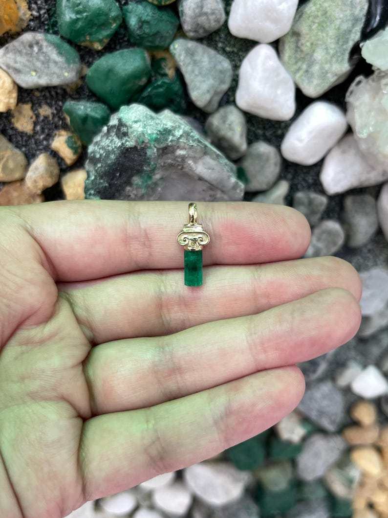 Vivid green Colombian rough emerald crystal pendant on a chain, 14K gold, showcasing natural gemstone with raw texture.