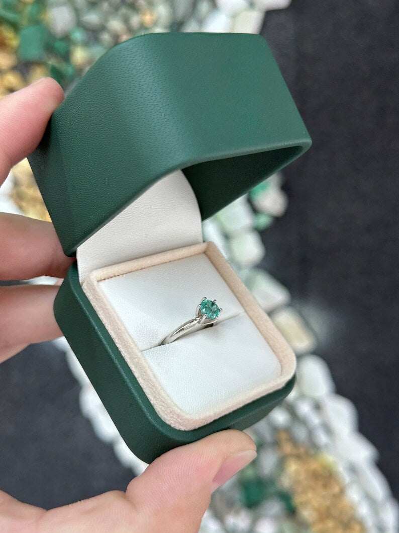 Ocean blue 0.80ct round cut emerald engagement ring in 14K gold with six prongs, by Colombian Emerald.